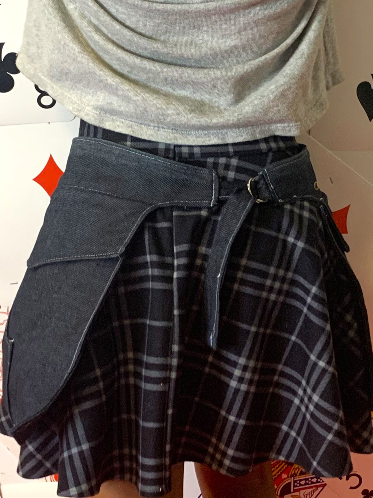 a back view of someone wearing a pair of midnight denim pockets in front of a background covered in playing cards
