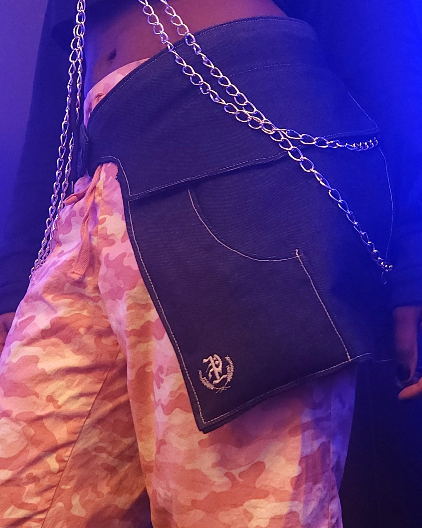A close-up of someone wearing a pair of midnight denim pockets bathed in blue light