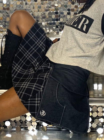 a side view close-up of someone wearing a pair of midnight denim pockets, sitting on a set if sequined stairs