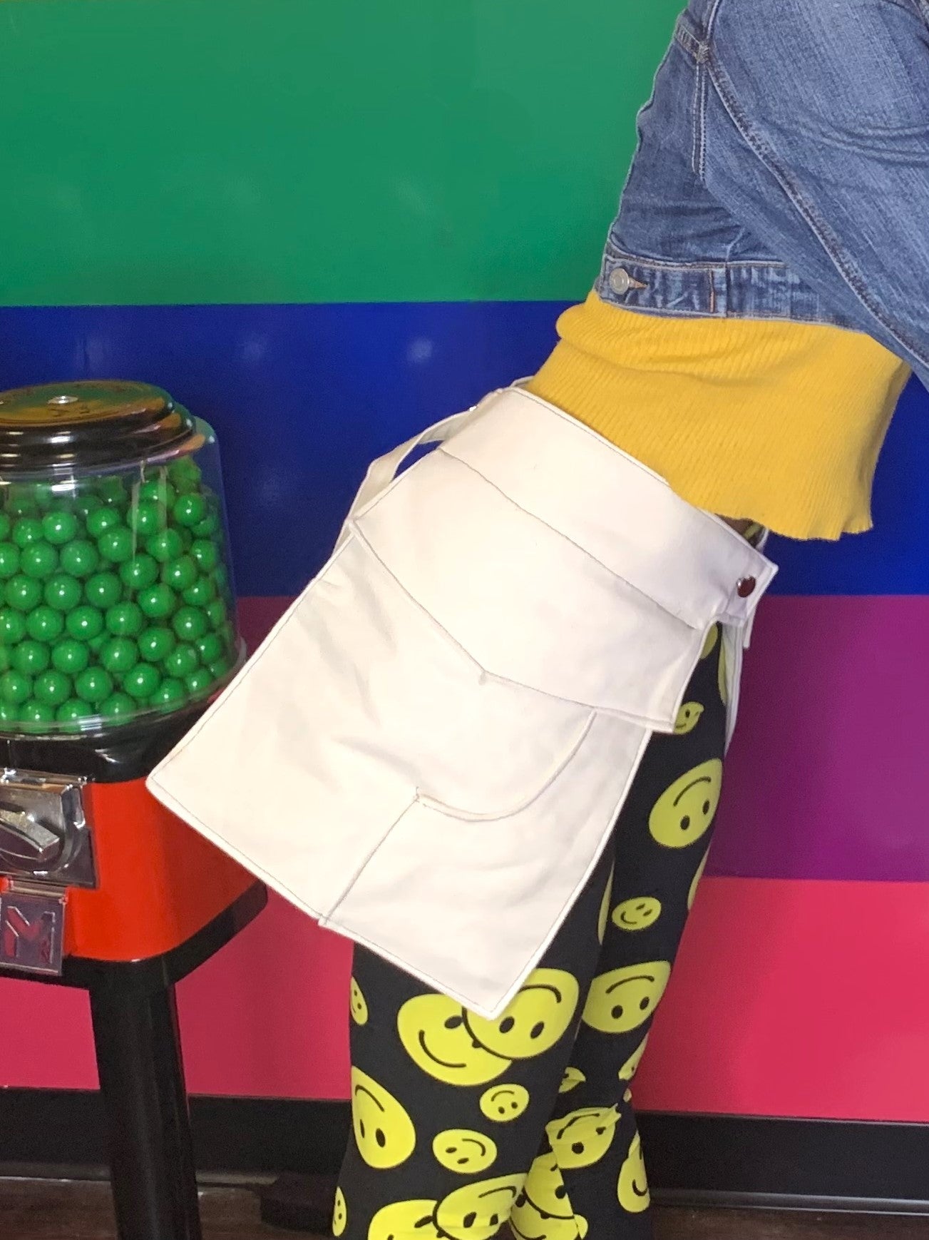 A side view of someone wearing a pair of off-white pockets in front of a colorful background.