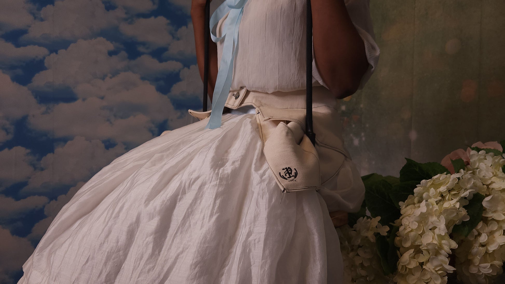 A 3/4 view of someone wearing a pair of off-white pockets while sitting on a swing