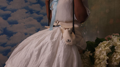 A 3/4 view of someone wearing a pair of off-white pockets while sitting on a swing
